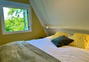 デュルビュイにあるBirdie Forest Lodge - voor golf & MTB, met bergingの窓のある部屋に枕が2つ置かれたベッド