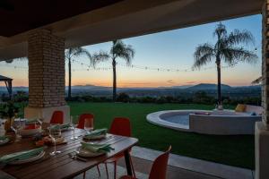 a patio with a table and chairs and a pool at The Grape Escape Panoramic Views In Wine Country in Temecula