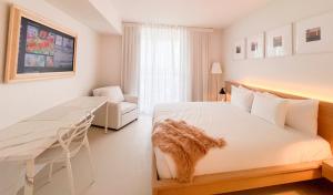 a bedroom with a bed and a desk and a chair at 1br BeachWalk Ocean View in Hallandale Beach +15 photos