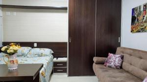 a living room with a bed and a couch at Baviera Studio Canela in Canela