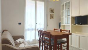 een woonkamer met een tafel en een bank bij Hostdomus - La casina di Monica in Loano