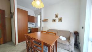 een woonkamer met een tafel en een bank bij Hostdomus - La casina di Monica in Loano