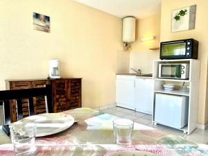 a kitchen with a table with a plate and a microwave at La Vallée Appartement 31 - Thermes Neyras les Bains in Meyras