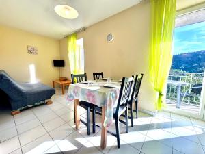 a dining room with a table and chairs and a window at La Vallée Appartement 31 - Thermes Neyras les Bains in Meyras