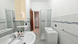 een badkamer met een wastafel, een toilet en een douche bij Hostdomus - La casina di Monica in Loano +6 foto's