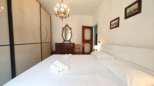 een slaapkamer met een groot wit bed met twee handdoeken bij Hostdomus - La casina di Monica in Loano