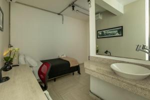 Un baño con un lavabo y una cama dentro. en Hotel 4 Living, en São Paulo