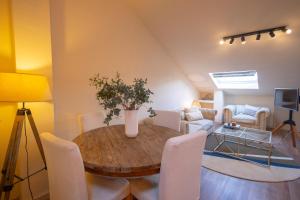 a living room with a wooden table and white chairs at Luz Marina in Ribadeo