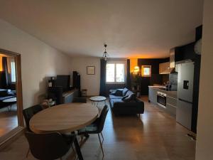 a kitchen and living room with a table and a couch at Appartement cocooning Sarrians in Sarrians