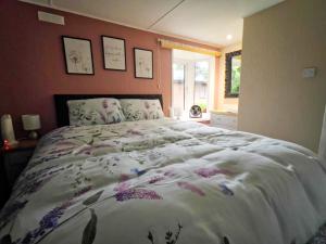 Un dormitorio con una cama grande con flores. en Lodge by the Lake - Lake District - Hot Tub, en Bassenthwaite