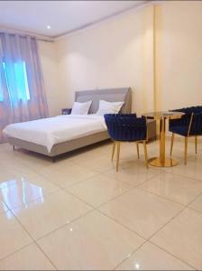 um quarto com uma cama, uma mesa e cadeiras em Bel'hôtel à 5mn de l'aéroport em Bangui