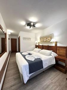 a bedroom with a large bed with white sheets at Hotel del centro in San Martín de los Andes