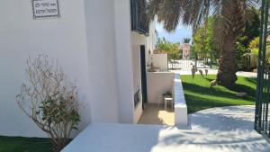 a white house with a courtyard with a palm tree at Like home at the Tehar-Lev family in Eilat