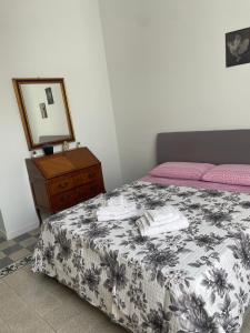 a bedroom with a bed and a dresser and a mirror at La Casa del Poeta 2 in Mercato San Severino
