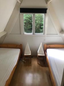 a attic room with two beds and a window at Villa Pimpelmees - Sunclass 54 in Durbuy +14 photos