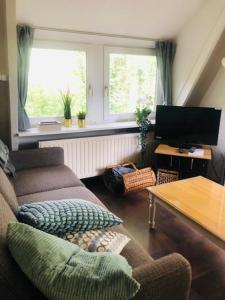 a living room with a couch and a television at Villa Pimpelmees - Sunclass 54 in Durbuy