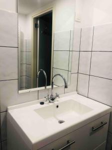 a bathroom sink with two faucets and a mirror at Villa Pimpelmees - Sunclass 54 in Durbuy