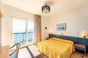 a bedroom with a bed and a large window at Hotel Souvenir in Lido di Jesolo +82 photos