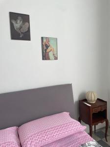 a bed with a pink comforter and a night stand at La Casa del Poeta 2 in Mercato San Severino +22 photos