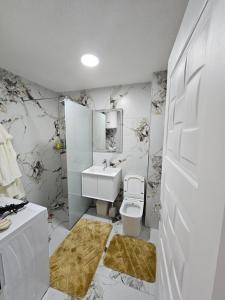 a white bathroom with a toilet and a sink at Besa Apartment in Ferizaj +19 photos