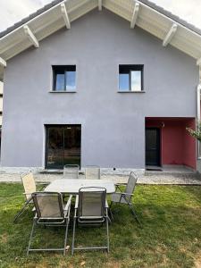 a table and chairs in front of a white house at La Félicita-Independent House-Terrace-8 Pers in Saint-Jean-de-Maurienne