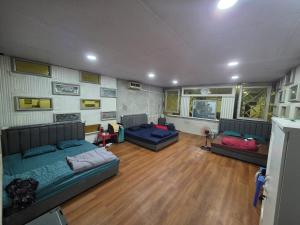 プノンペンにあるRed & Blue Guesthouseのソファ付きの広いリビングルーム(ウッドフロア)