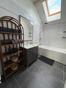 a bathroom with a sink and a tub and a mirror at La Félicita-Independent House-Terrace-8 Pers in Saint-Jean-de-Maurienne