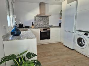 a kitchen with a refrigerator and a washer and dryer at Hello Oliva Beach Roger in Oliva