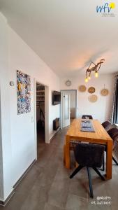 ein Esszimmer mit Tisch und ein Wohnzimmer in der Unterkunft Haus Möwennest Ferienwohnung Kiek op de Toorns in Borkum