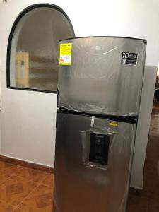 a metal refrigerator with a window in a room at Apartamentos contiguos cerca a Parque de Bello Antioquia in Bello