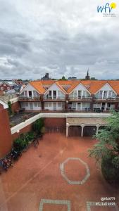 ein großes Gebäude mit roten Ziegeldächern und einem Innenhof in der Unterkunft Haus Möwennest Ferienwohnung Kiek op de Toorns in Borkum + 24 Fotos