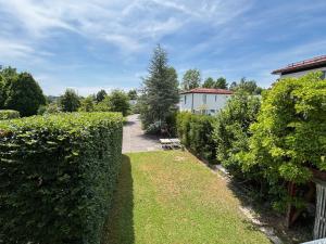 a garden with hedges and a pathway at Schatzlhof Suite in Berg am Starnberger See in Berg am Starnberger See