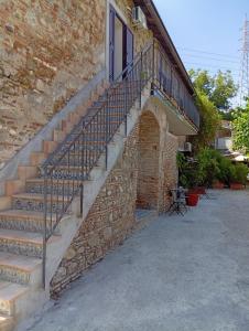 a brick building with a staircase next to a building at La tenuta Moscatella a 200m dal mare in Schisò