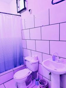 a white bathroom with a toilet and a sink at Miami Studios DR in Santo Domingo