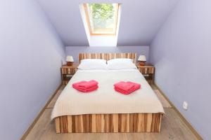 a bedroom with a bed with two pink slippers at Abies Villa in Zagnańsk
