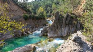 Un río con agua azul y rocas en un cañón en Precioso Apartamento en Cazorla con vista a la montaña, naturaleza, WI FI gratuito, en Cazorla