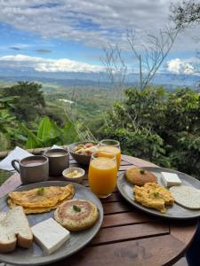 ManzanilloGlamping Aire Sevilla Valle的桌子上摆满了食物和橙汁 更多17张照片