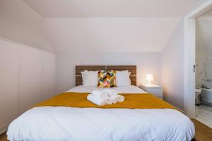 a bedroom with a large white bed with towels on it at The Shoreline 4 by Portugal Portfolio in Parede