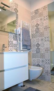 bagno con lavandino, servizi igienici e specchio di Exclusive Suite San Biagio 25 a Napoli