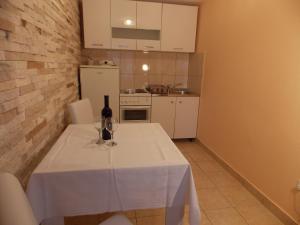 a table with a bottle of wine and glasses on it at Apartments and Rooms Jasna in Hvar