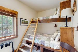a bedroom with two bunk beds and a lamp at Cozy Cabin Retreat in Grand Lake