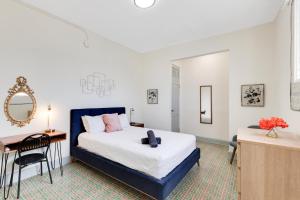 Chic & Cozy Stay in Trendy Miramar في سان خوان: غرفة نوم بها سرير ومكتب ومرآة