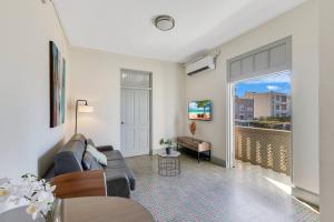 Chic & Cozy Stay in Trendy Miramar في سان خوان: غرفة معيشة مع أريكة وشرفة