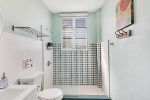 Chic & Cozy Stay in Trendy Miramar في سان خوان: حمام مع دش ومرحاض +13 صورة