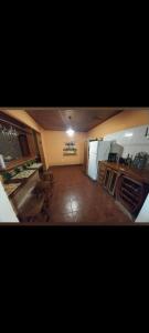 a large kitchen with a table and a refrigerator at La casita piso compartido in Puerto Iguazú