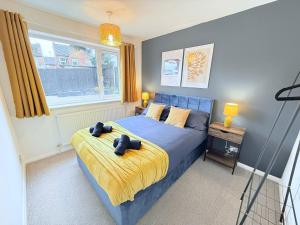 a bedroom with a blue bed with two stuffed animals on it at Bungalow 2BR Parking Shower in Heanor