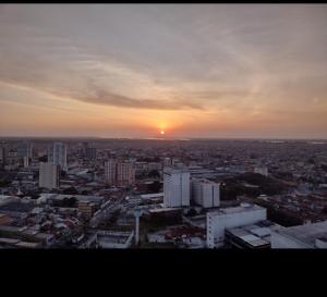a view of a city with the sunset in the background at Flat Studio em Belém mobiliado in Belém
