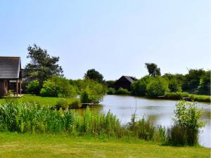 a view of a river with a house in the background at Elm 34 Hot Tub in Garton +7 photos