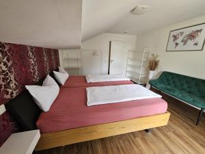 a bedroom with two beds and a green couch at RoSa Seeblick in Steingaden