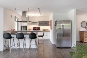 een keuken met een roestvrijstalen koelkast en barkrukken bij Achtern Hoff in Gnissau